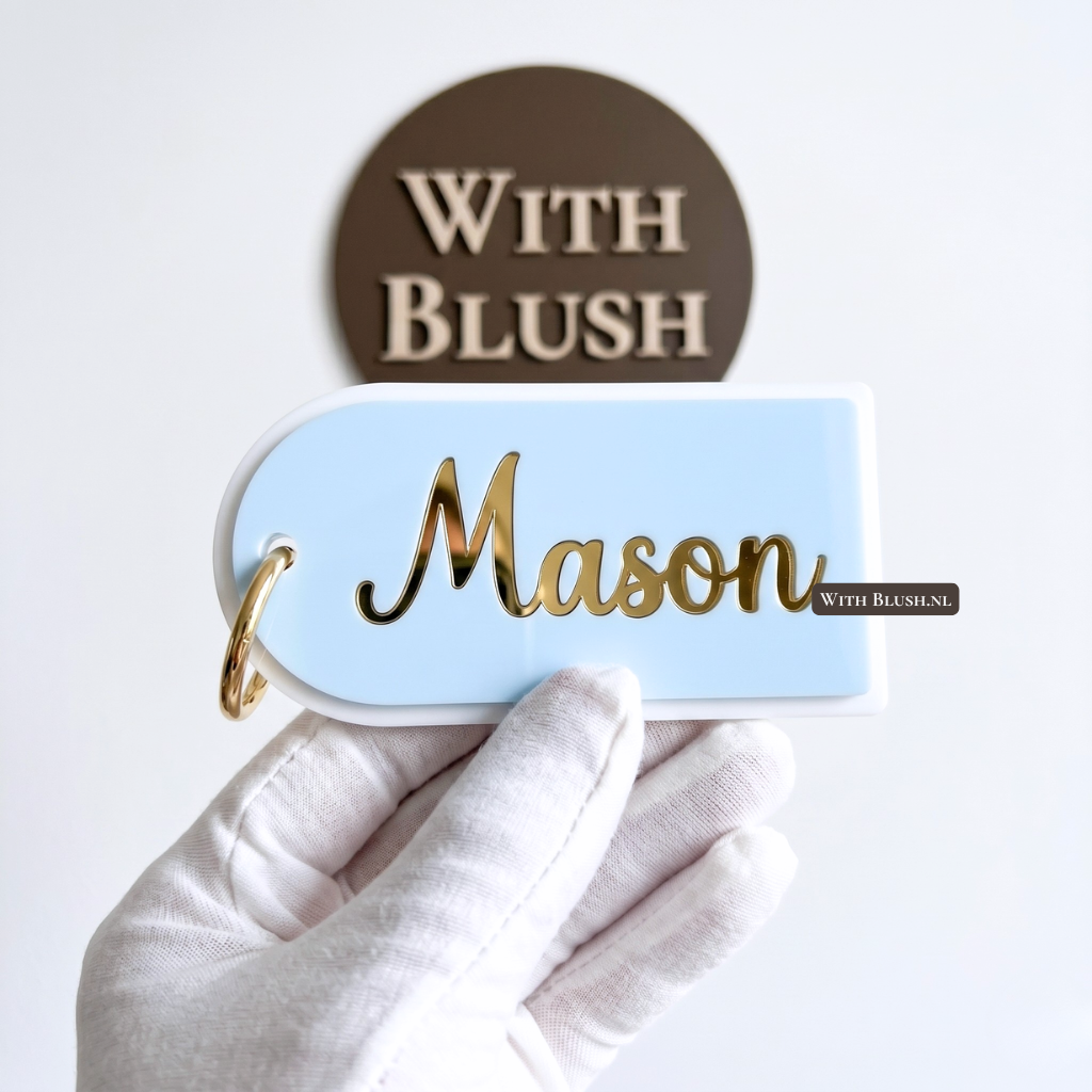 Luxe boogvormig naamlabel voor een schooltas gemaakt van lichtblauw plexiglas. De naam Mason is nauwkeurig uitgesneden uit een toplaag en afgewerkt in een modern, sierlijk spiegelgoud lettertype. Voorzien van een ronde gouden karabijnhaak.