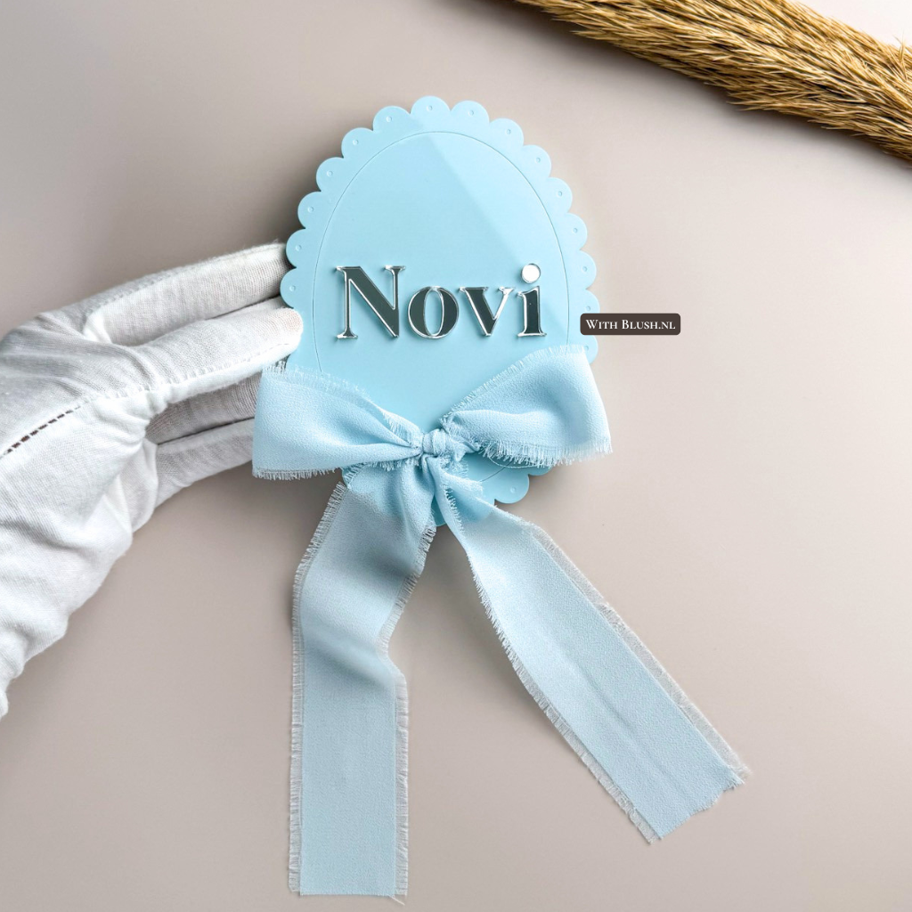 Vintage ovaal naambord van glanzend blauw plexiglas met uitgesneden naam en blauwe lintstrik