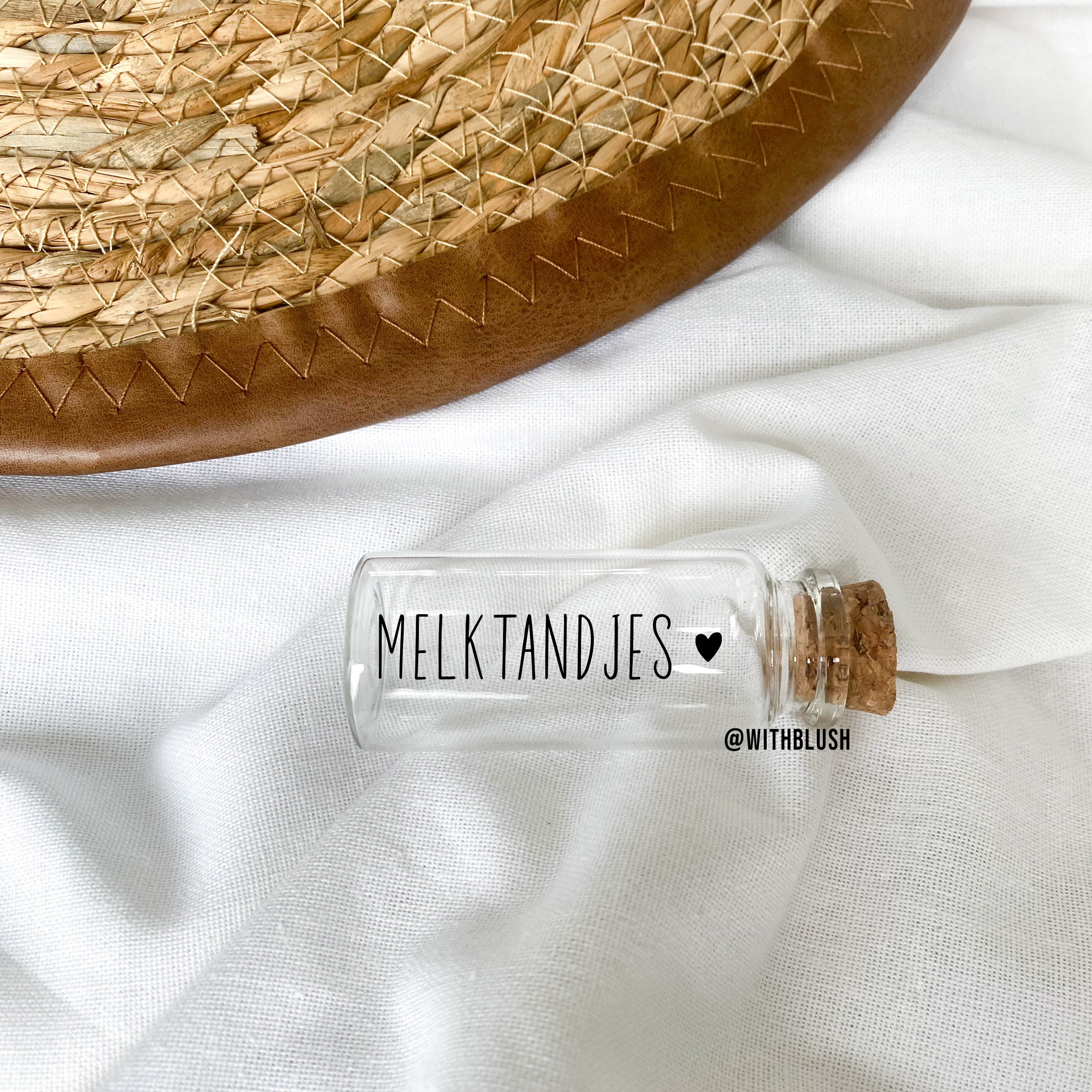 Glazen bewaarbuisje met kurk en gouden naamstickers voor melktandjes