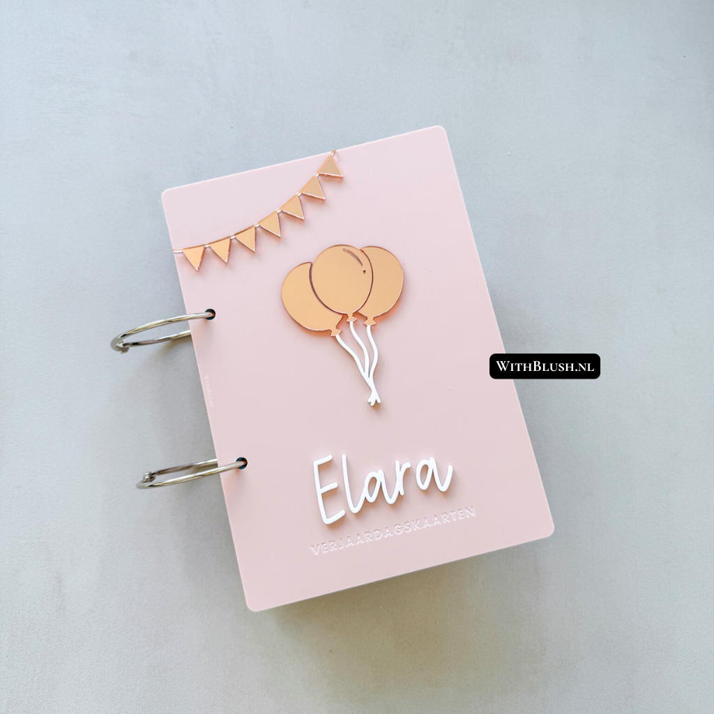 Voorzijde van plexiglas bewaarmap met gepersonaliseerde naam, slinger en ballonnen