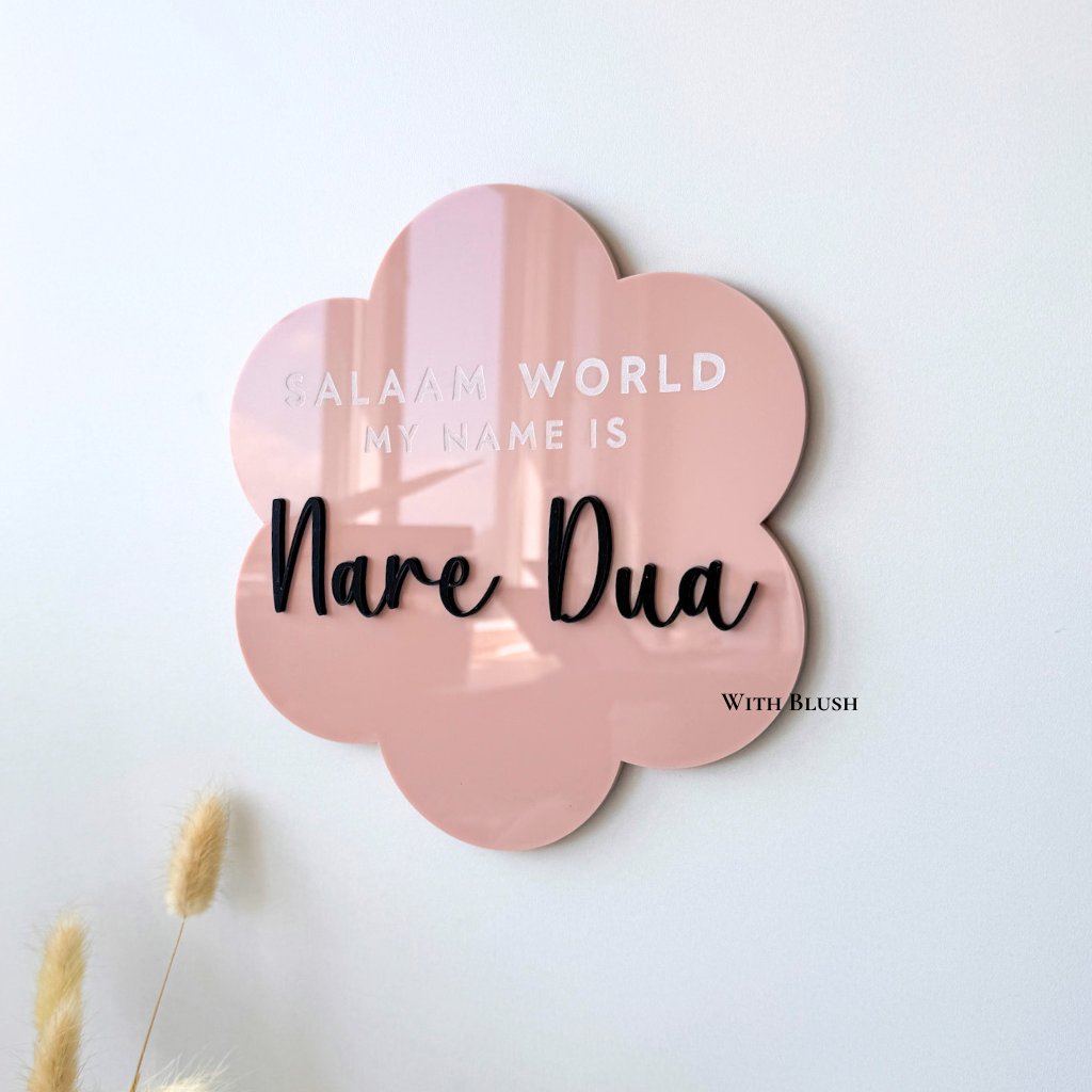 Detailfoto van roze en zwart plexiglas naamdecoratie, perfect voor babykamer of als kraamcadeau.