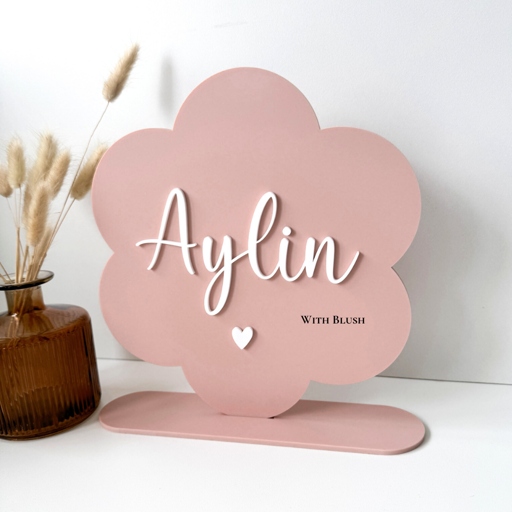 gepersonaliseerde naambord in de vorm van een madeliefje in roze gekleurd plexiglas met standaard