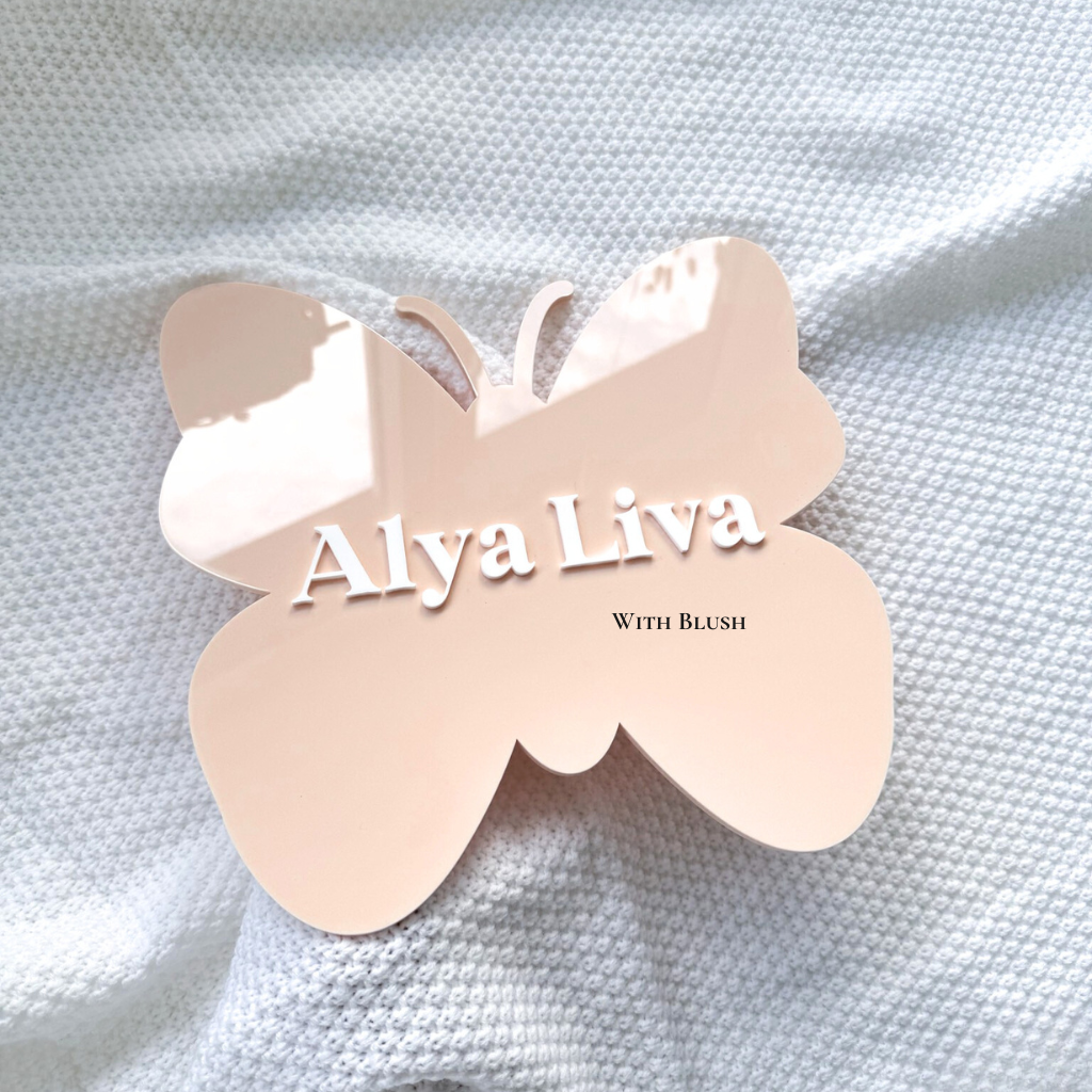 geboortebord in de vorm van een vlinder in de kleur peach, gepersonaliseerd van wit plexiglas