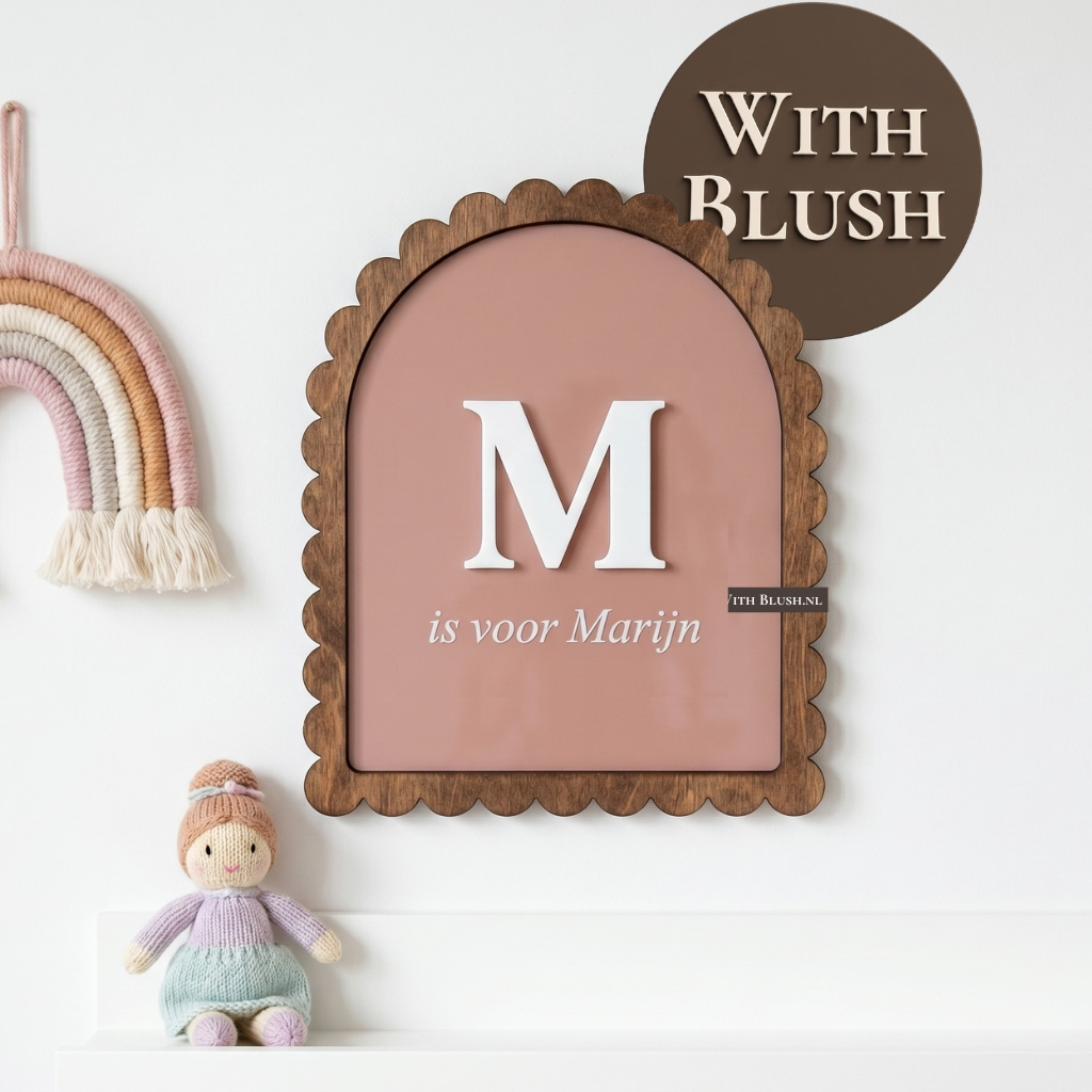 Vooraanzicht van een gepersonaliseerd oudroze plexiglas naambordje met een houten schelprand, een witte 3D letter en een gegraveerde naam voor in de babykamer.
