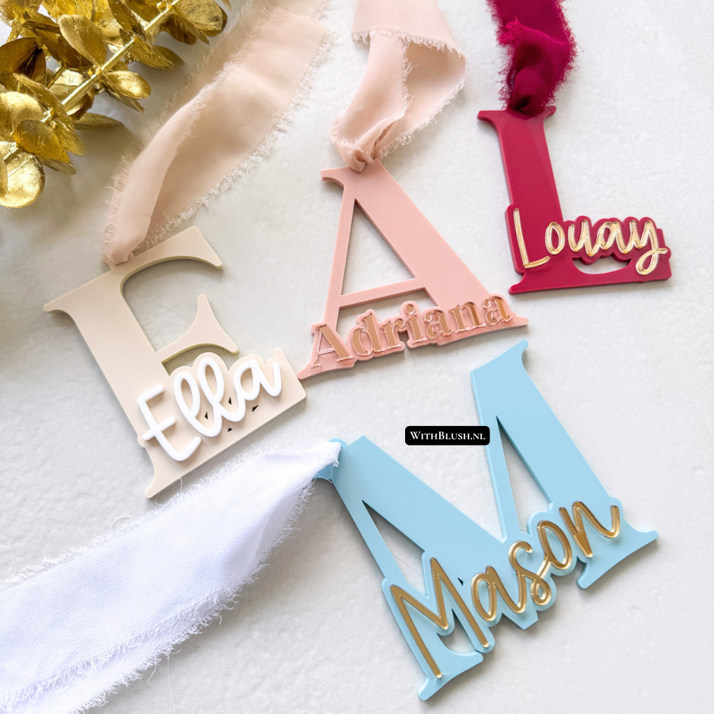 Gepersonaliseerde kerstdecoratie van plexiglas met uitgesneden initiaal en naam, afgewerkt met lint naar keuze voor in de kerstboom