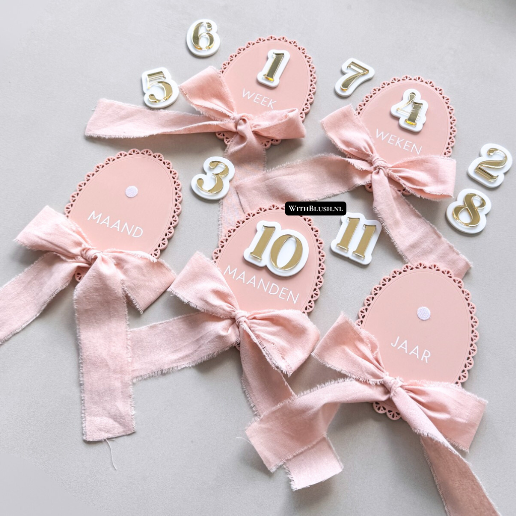 Vintage ovale mijlpaalkaart van plexiglas in mauve glossy uitvoering, met zelfklevende gouden cijfers en bijpassend lint, stijlvol gepresenteerd