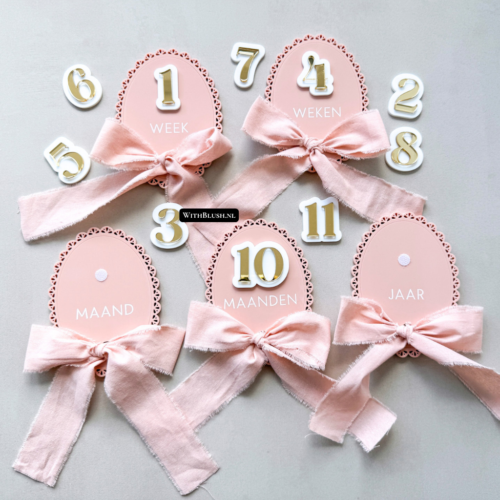Mijlpaalkaart in ovale vorm, kleur mauve glossy, met goudkleurige losse cijfers en witglanzende achtergrond, afgewerkt met mauvekleurig lint