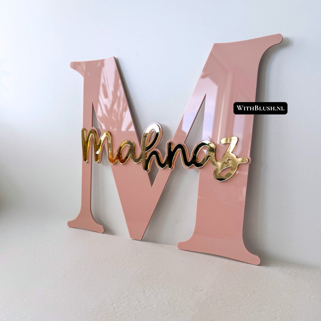 Elegant naambord met hoofdletter in mauve glossy plexiglas en naam in gold mirror plexiglas. Een warme en chique combinatie, perfect als persoonlijke wanddecoratie of cadeau voor een geboorte of verjaardag.