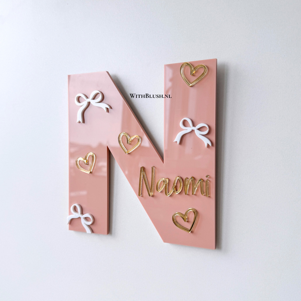 Naambord letter met naam, witte plexiglas strikjes en goud spiegel-hartjes