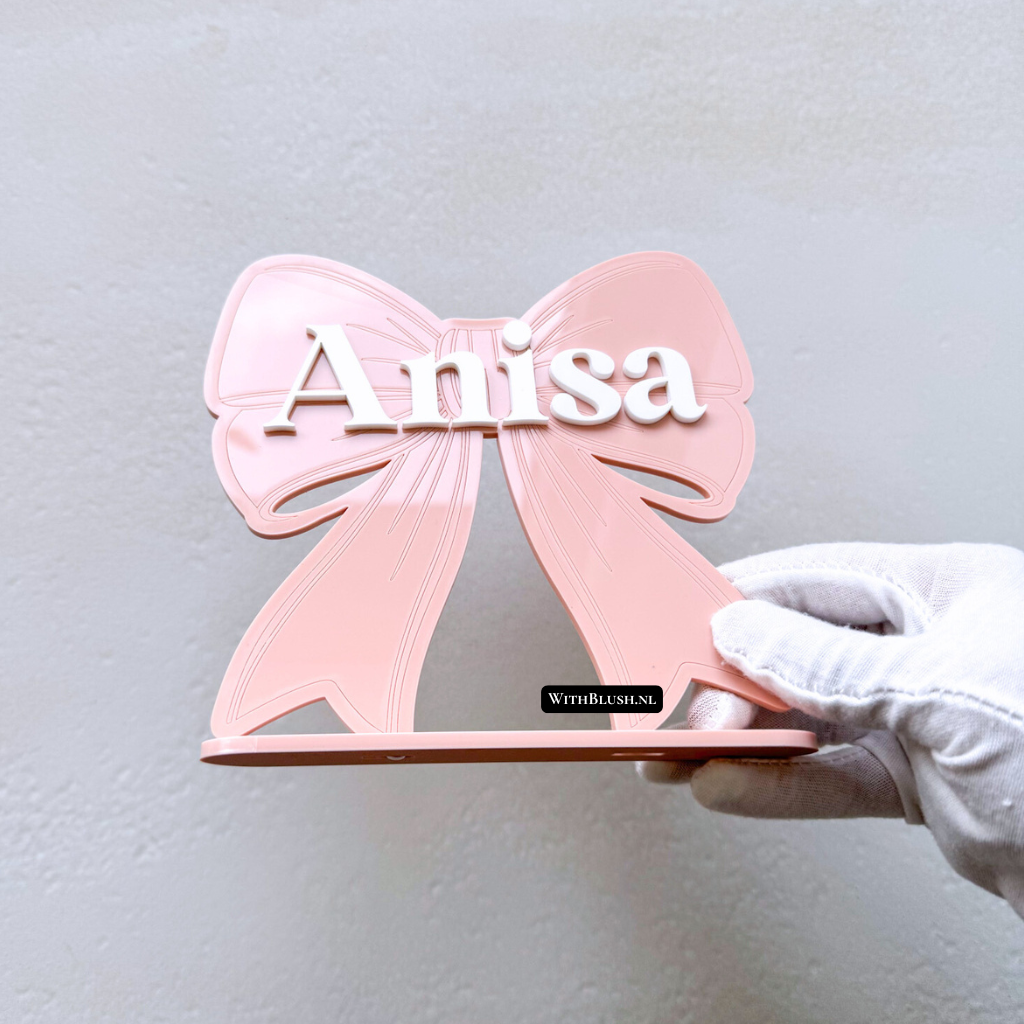 strikje met naam en standaard van roze plexiglas