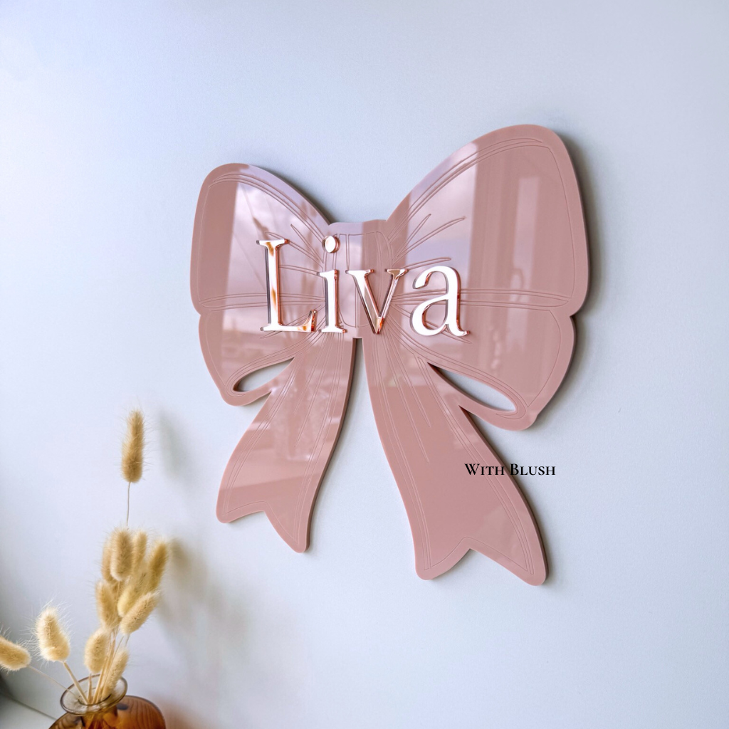 gepersonaliseerde naambord in de vorm van een strik met naam van gekleurd plexiglas