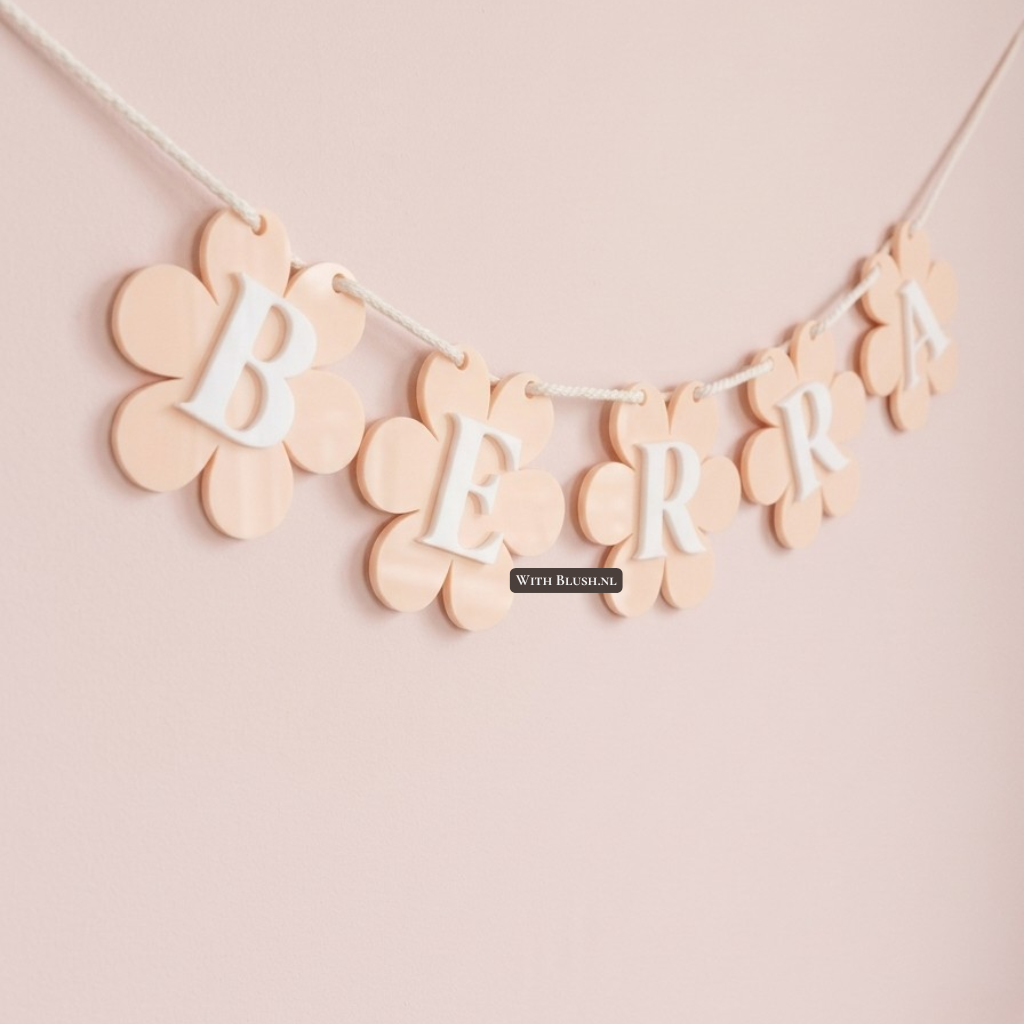 Perzikkleurige vlaggenlijn met madeliefjes en een uitgesneden naam van acryl plexiglas. Een prachtig gepersonaliseerd kraamcadeau of decoratie voor de kinderkamer.