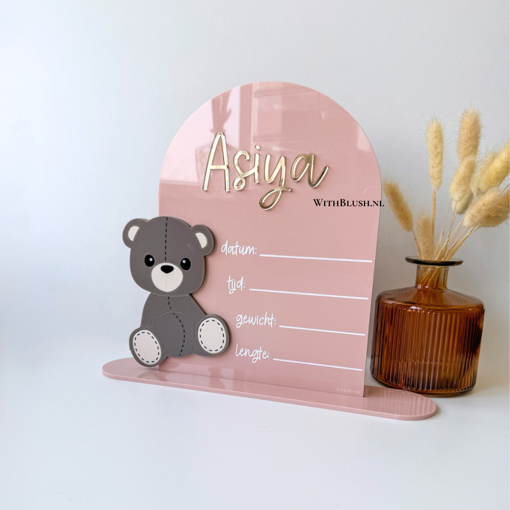 Geboortebord in gebogen vorm van glanzend plexiglas met een schattige teddybeer en bijpassende strik, gepersonaliseerd met de naam van het kindje en ruimte om geboortedetails in te vullen; verkrijgbaar in verschillende kleuren, geschikt om neer te zetten of op te hangen.