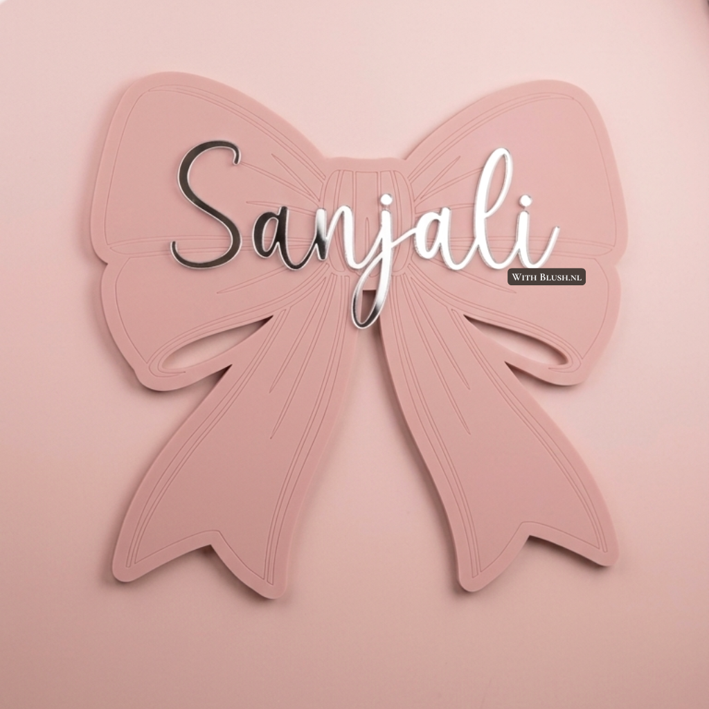 Oudroze acryl strik met de naam Sanjali in zilveren script letters, luxe muurdecoratie voor de kinderkamer.
