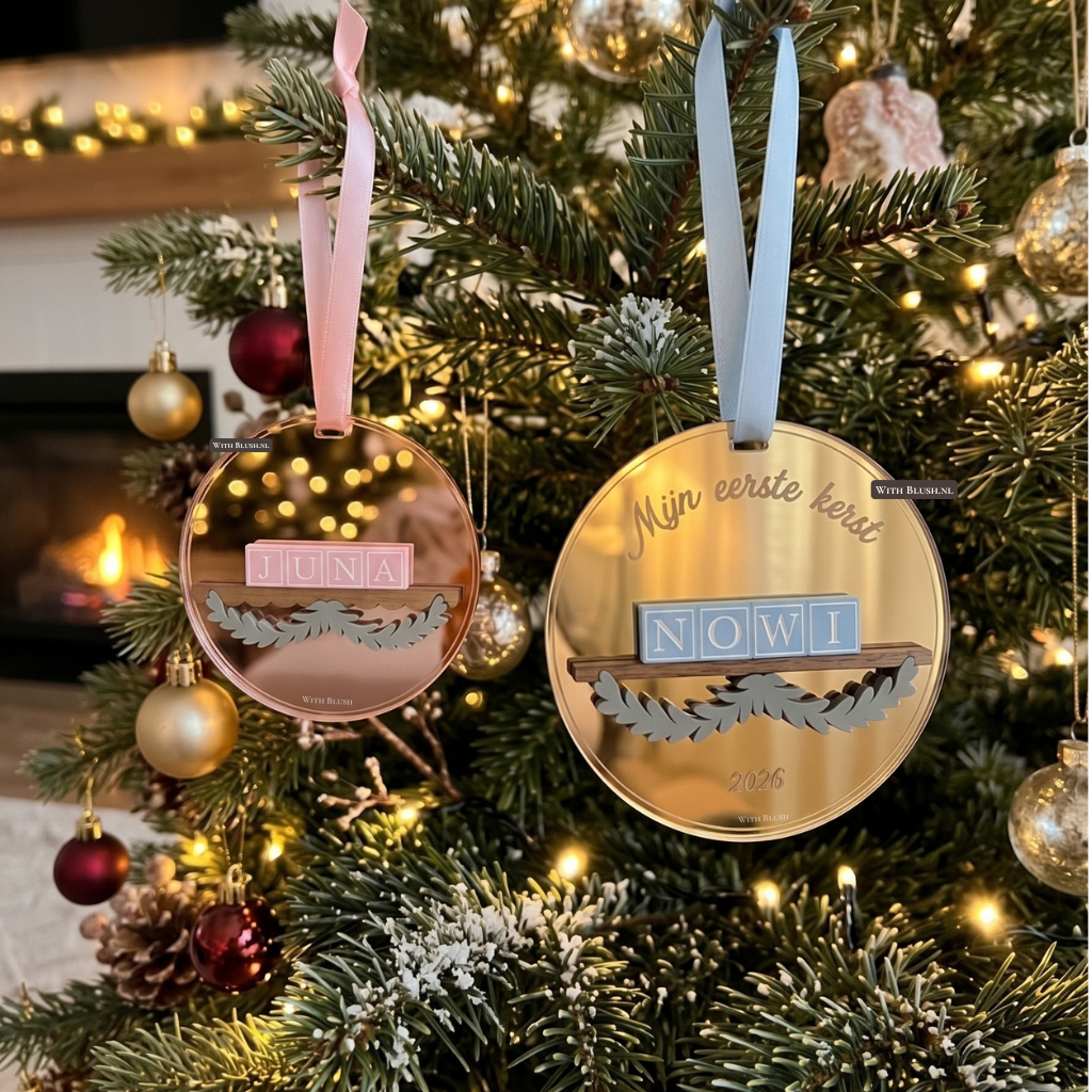 Ronde spiegel plexiglas kerstbal met een houten plankje en bladerkrans, voorzien van een naam in 3D letterblokjes en een lintje.