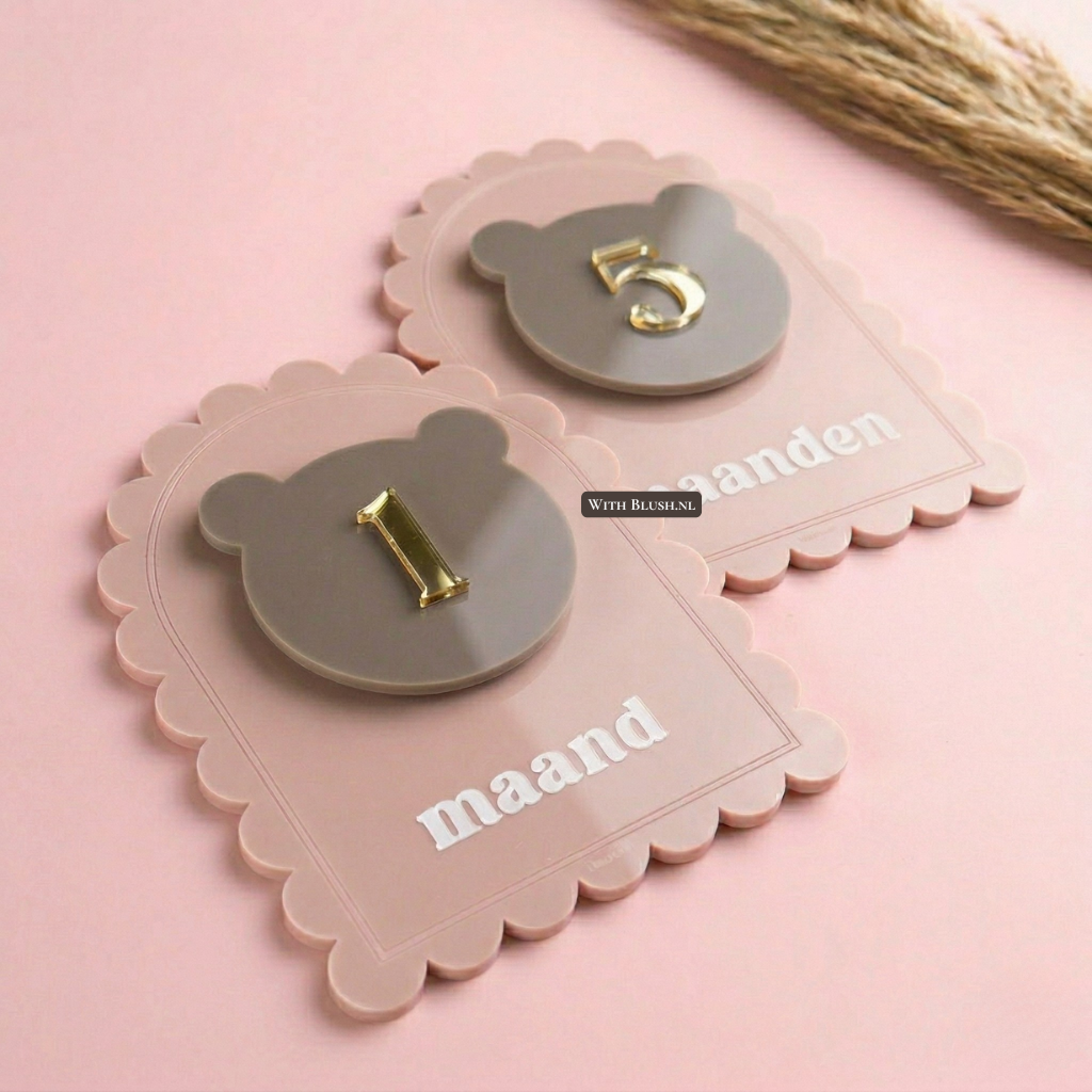 Luxe acryl mijlpaalkaarten set voor baby's in oudroze met verwisselbare teddybeer-inlegstukken. De set toont '1 maand' en 'maanden' met een gouden 3D-nummer '1' en '5'. Geschikt voor het vastleggen van mijlpalen van 1 maand tot het eerste jaar, perfect als kraamcadeau