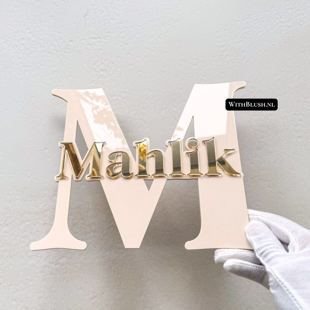Gepersonaliseerd naambord met hoofdletter in beige glossy plexiglas en naam in gold mirror plexiglas. Stijlvolle en tijdloze decoratie voor de kinderkamer, met elegante glans en luxe uitstraling.