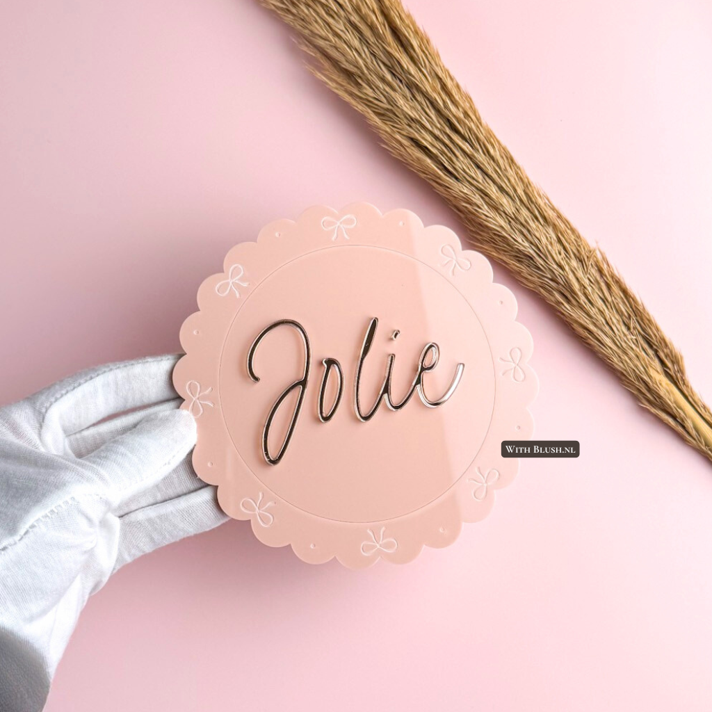 Gepersonaliseerd rond naambord van roze acryl voor babykamer met geschulpte rand en strikjes in van spiegel plexiglas