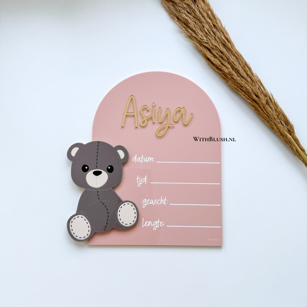 Geboortebord van glanzend plexiglas met teddybeer en strik, inclusief gepersonaliseerde naam en mogelijkheid om datum, tijd, gewicht en lengte in te vullen; optioneel met standaard, ideaal als persoonlijk geboortecadeau of decoratie voor de babykamer.